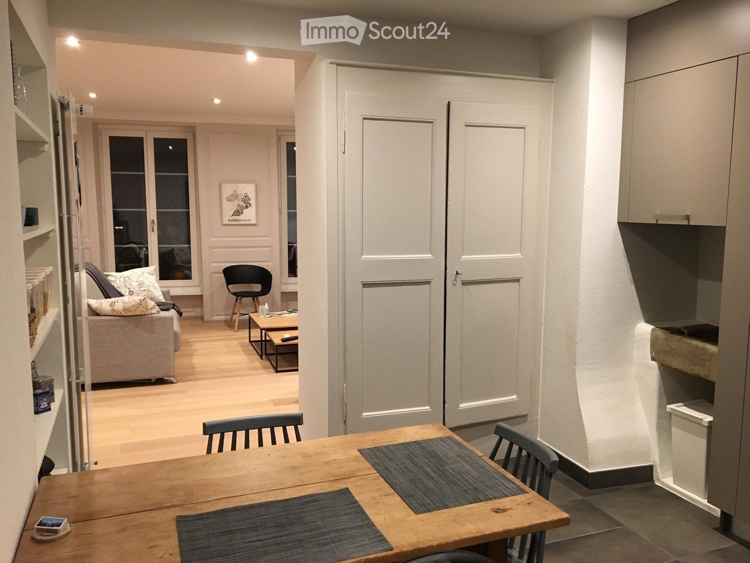 Open-plan living and dining area with a sofa, coffee table, dining table, chairs, and built-in cabinets.