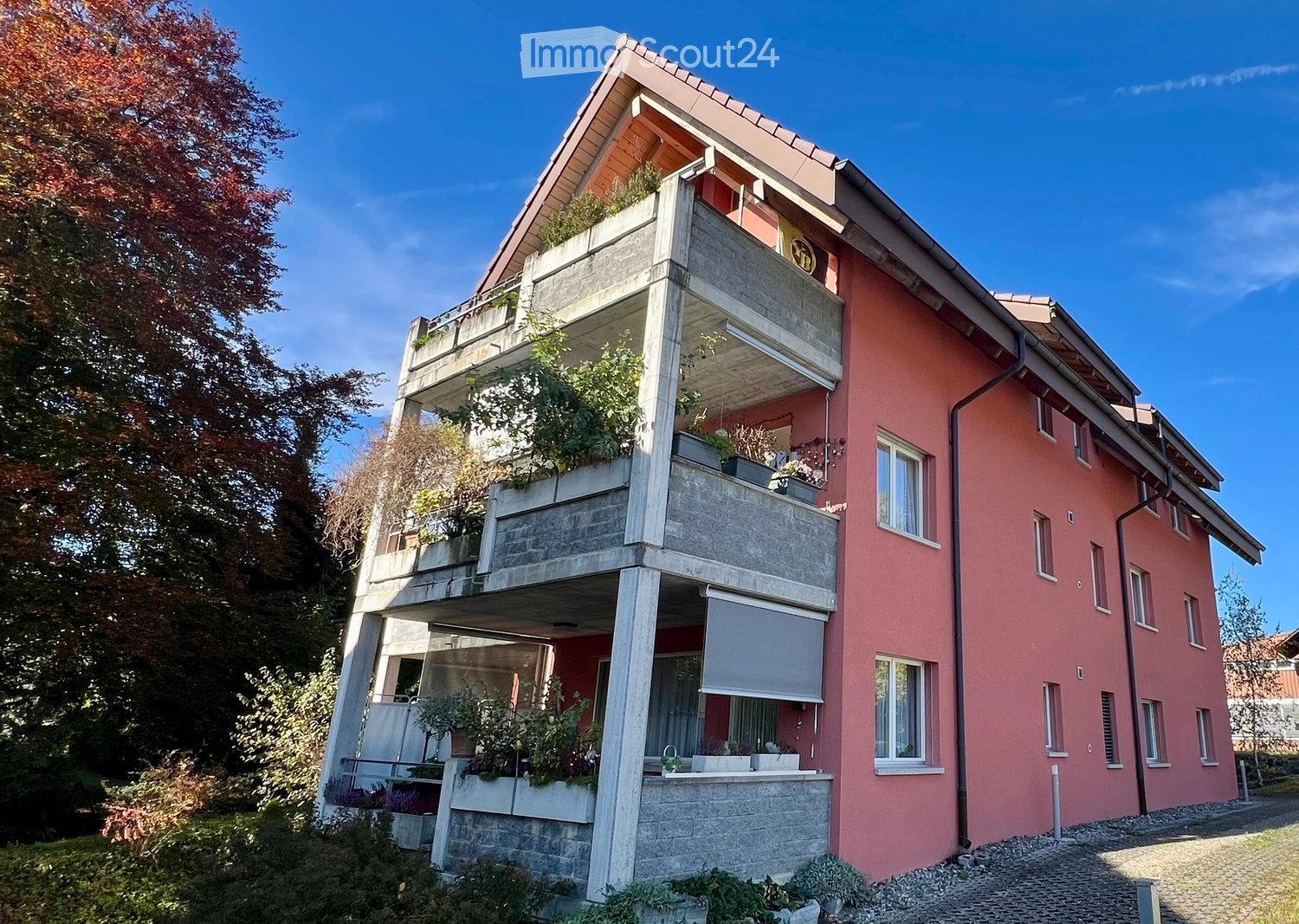 3 story house, red brick, white windows, balcony, plants