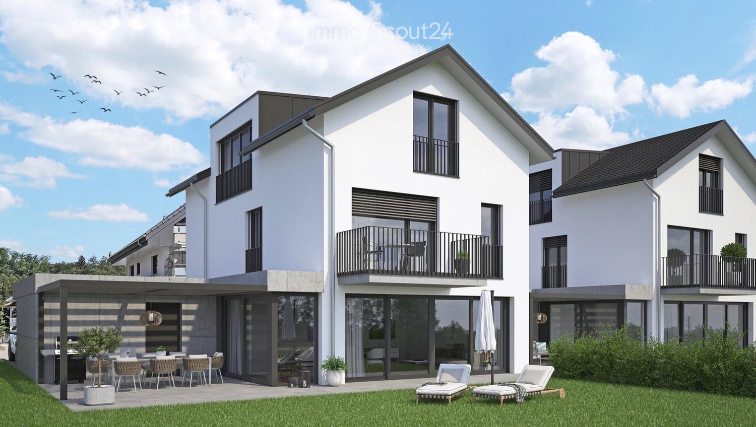 Modern two-story house with white exterior, large windows, balconies, and a spacious outdoor patio area with lounge chairs and a dining set.