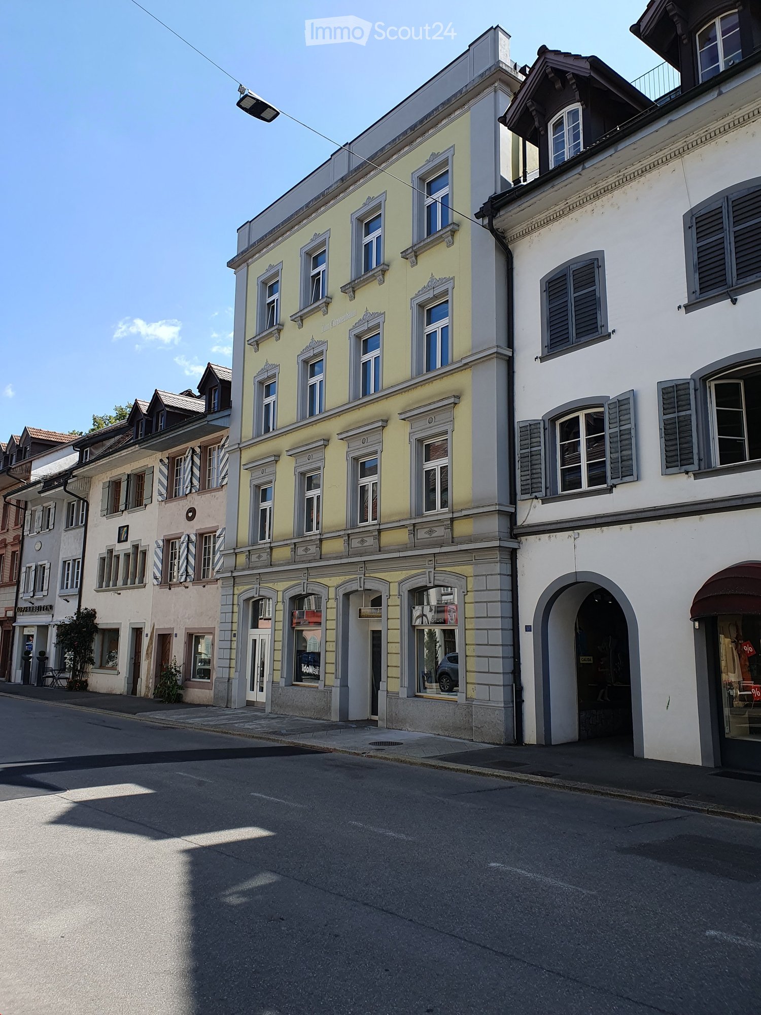 A row of buildings with multiple windows and a street light above the road