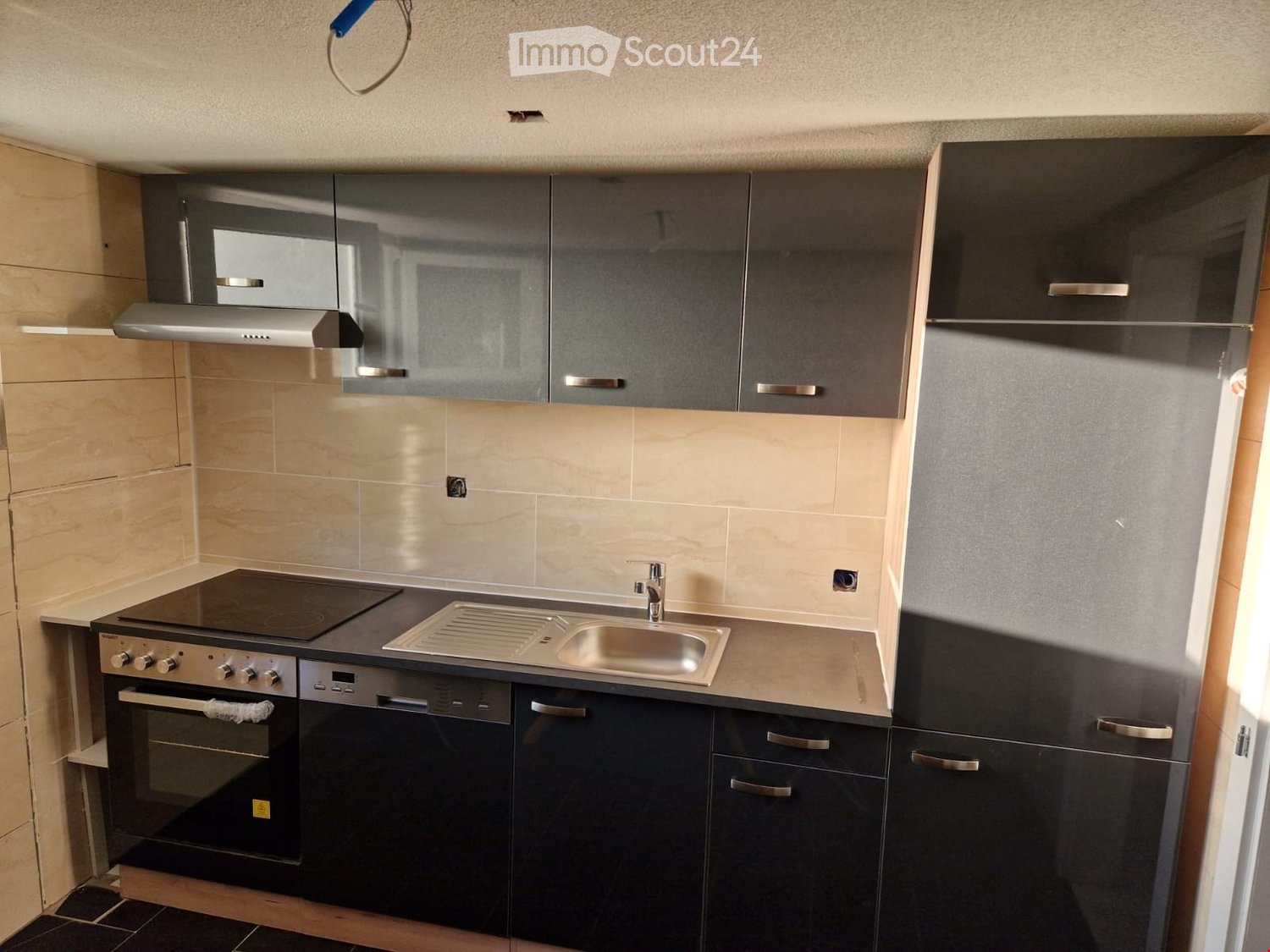 modern kitchen with black cabinets, stainless steel countertop, gas stove, oven, sink, and dishwasher