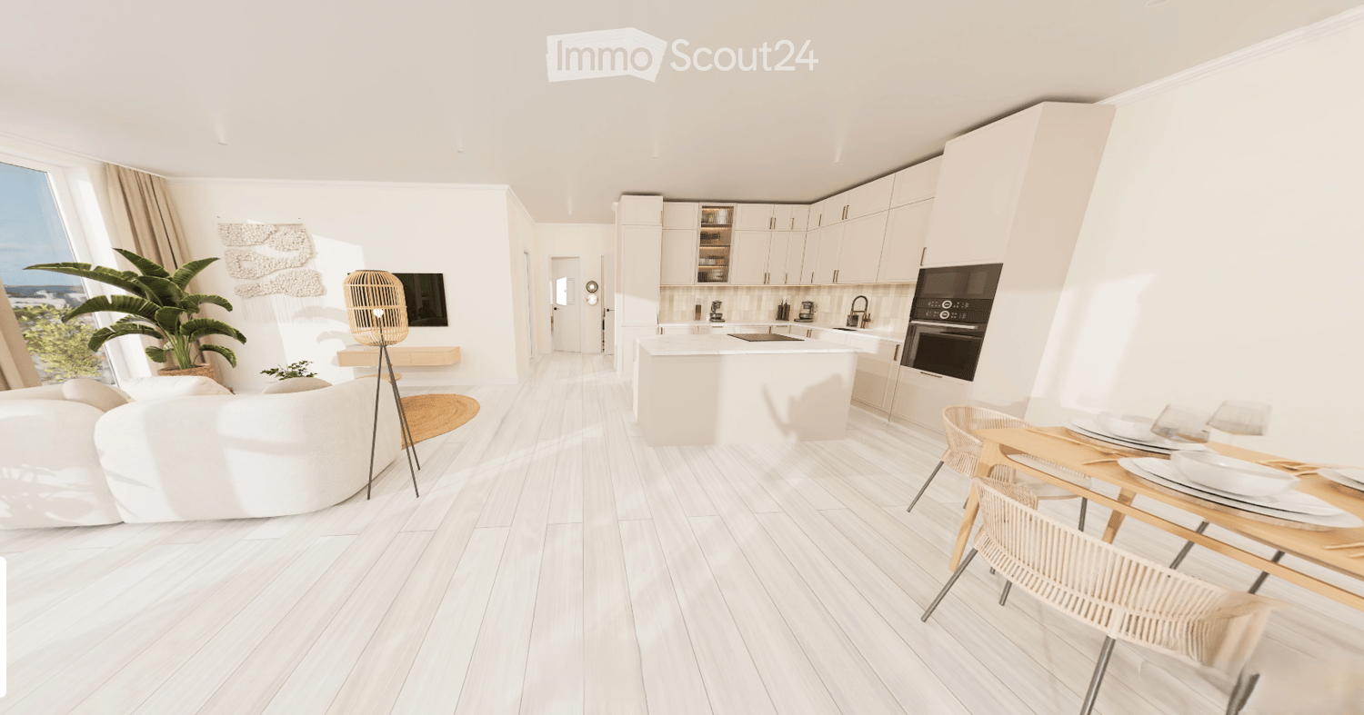 Modern, open-plan living and dining area with white walls, light wood flooring, and large windows offering a scenic view. Features a white sectional sofa, coffee table, floor lamp, TV, kitchen island with appliances, and a dining table with chairs.