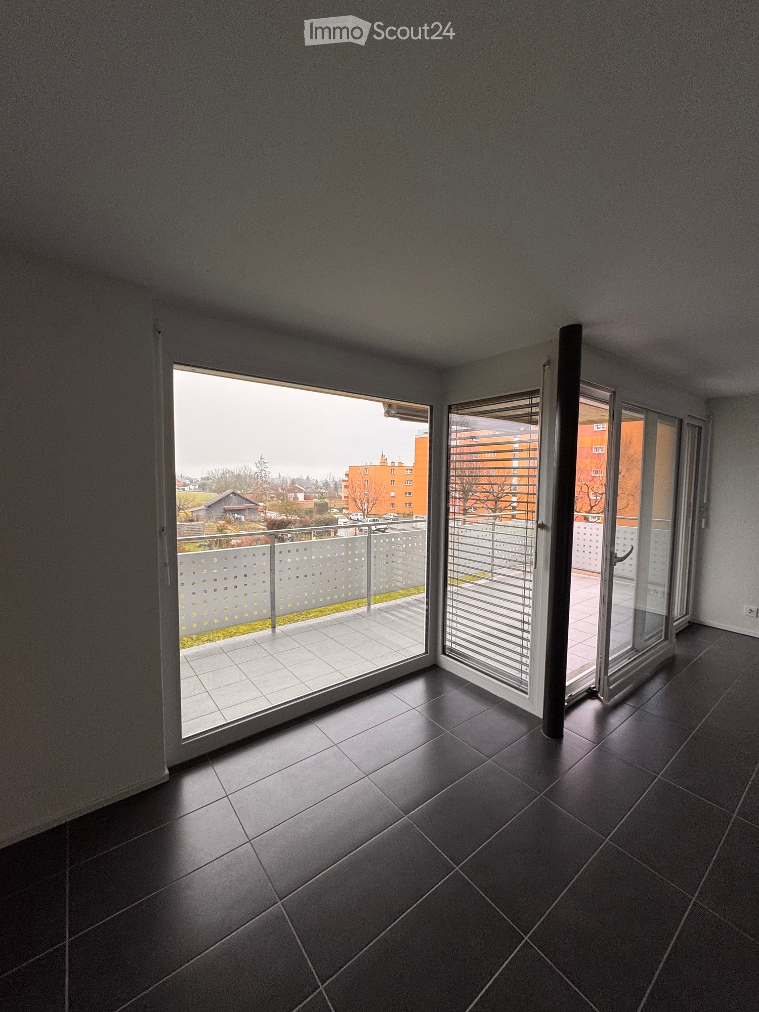 empty room with glass sliding doors, balcony, parquet floor