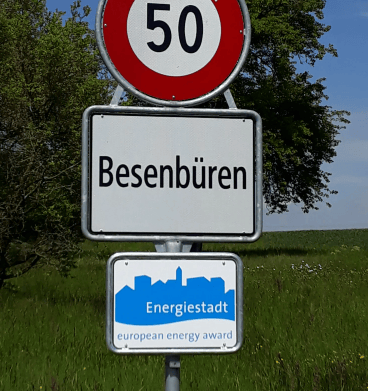 Road sign displaying speed limit of 50 km/h and the name "Besenbüren" with an additional "Energiestadt" award sign below.