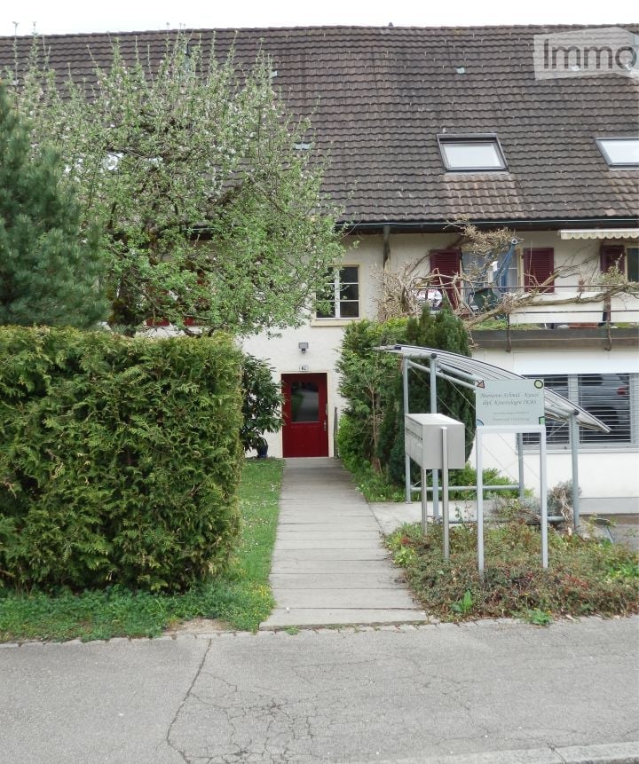 2 story house, brown roof, red door, white walls, hedges, walkway, mailbox