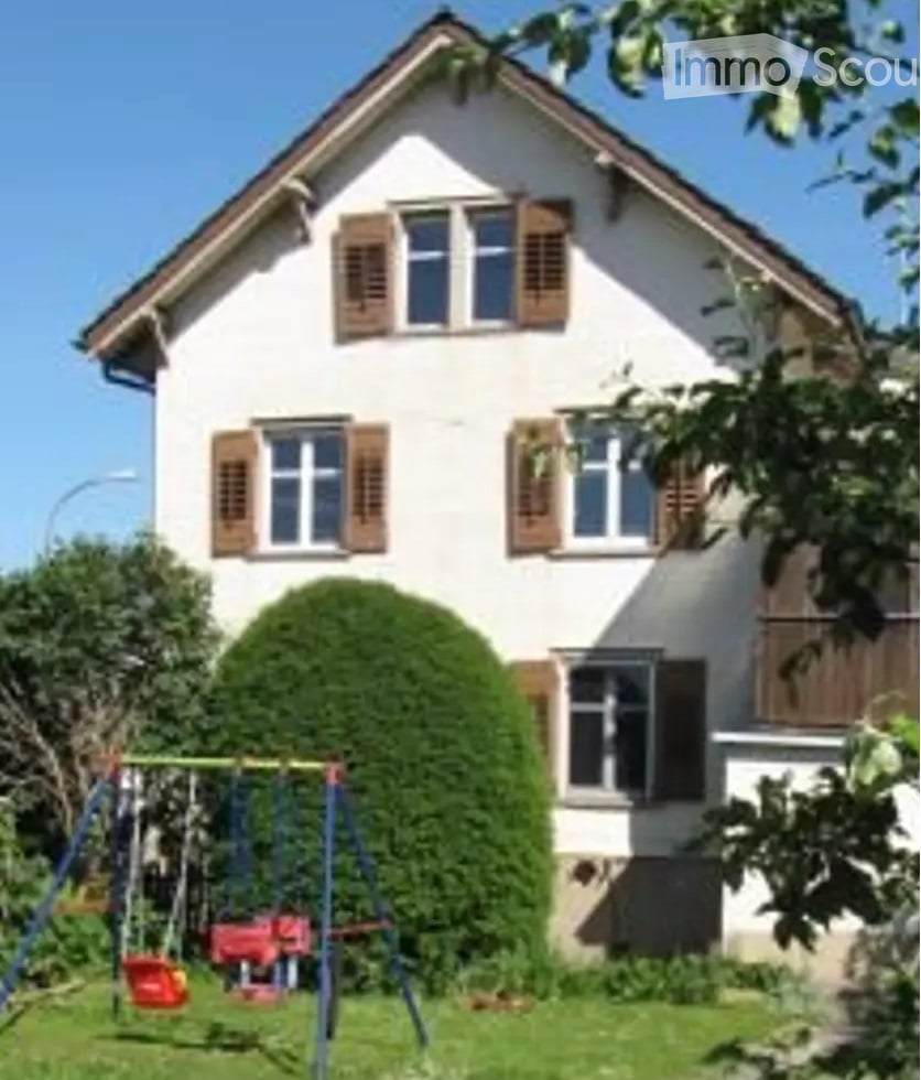 white 2 story house, brown shutters, red swing, green hedge, grass