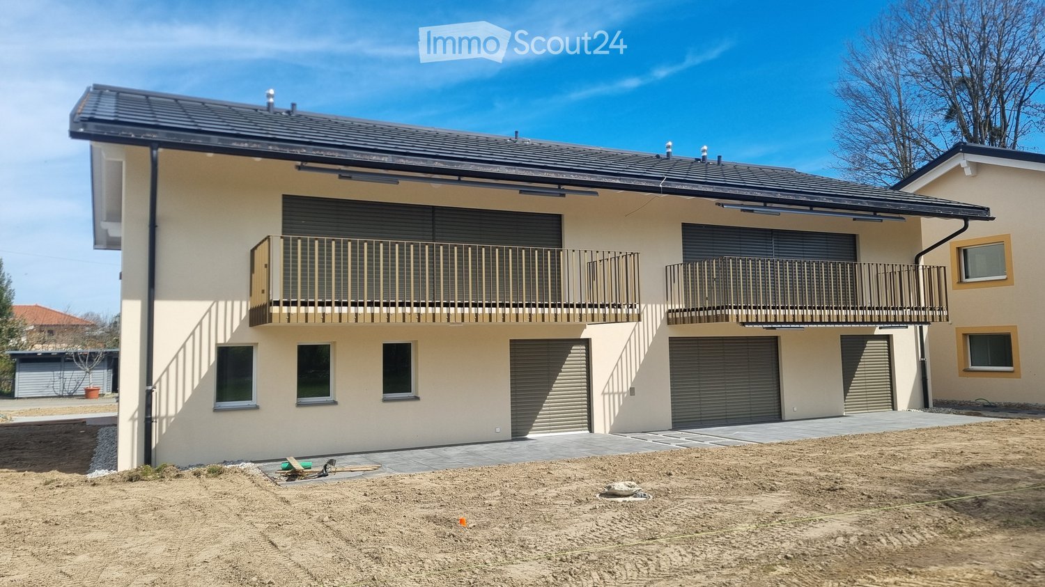 2 story house, beige exterior, black roof, 2 garages, 2 balconies