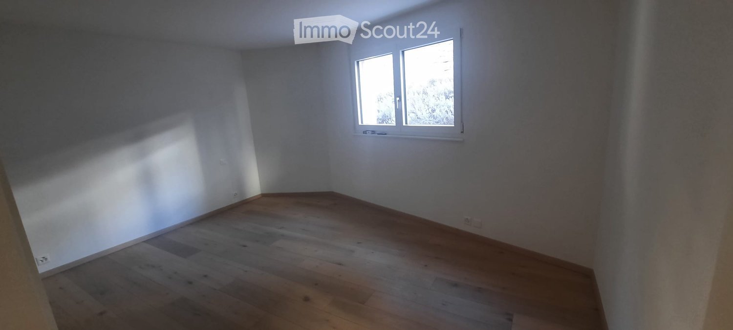 Empty room with wooden flooring and white walls, featuring a single window with white frame and blinds.