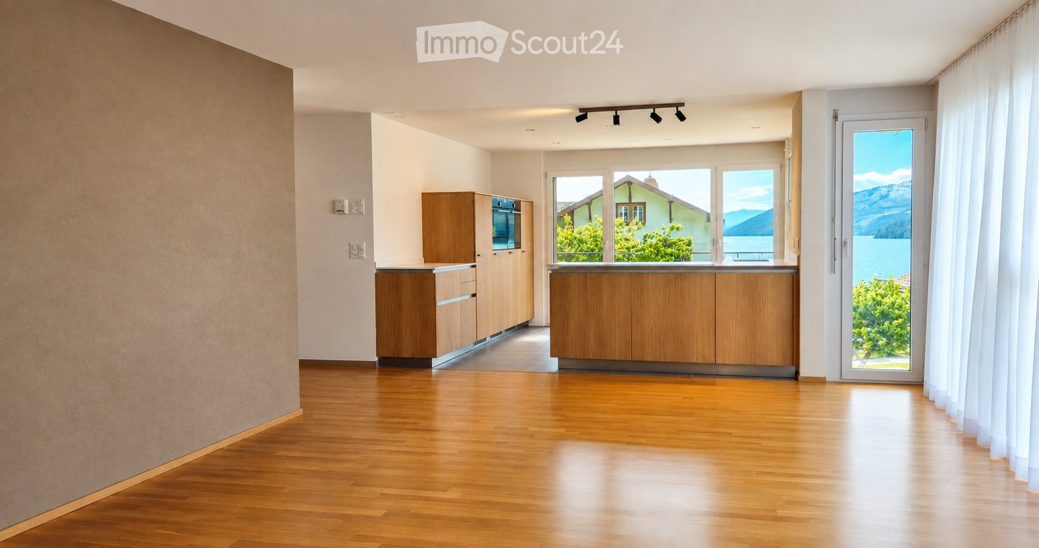 Modern kitchen with light wooden cabinets, stainless steel oven, and large windows offering a scenic view of a lake and mountains.