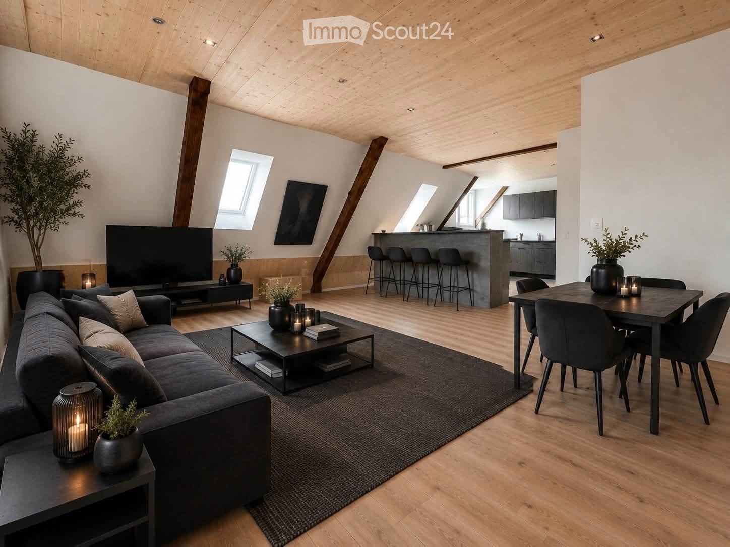 Modern living and dining area with exposed wooden beams, large windows, grey sofa, coffee table, dining table, bar counter, and decorative plants.