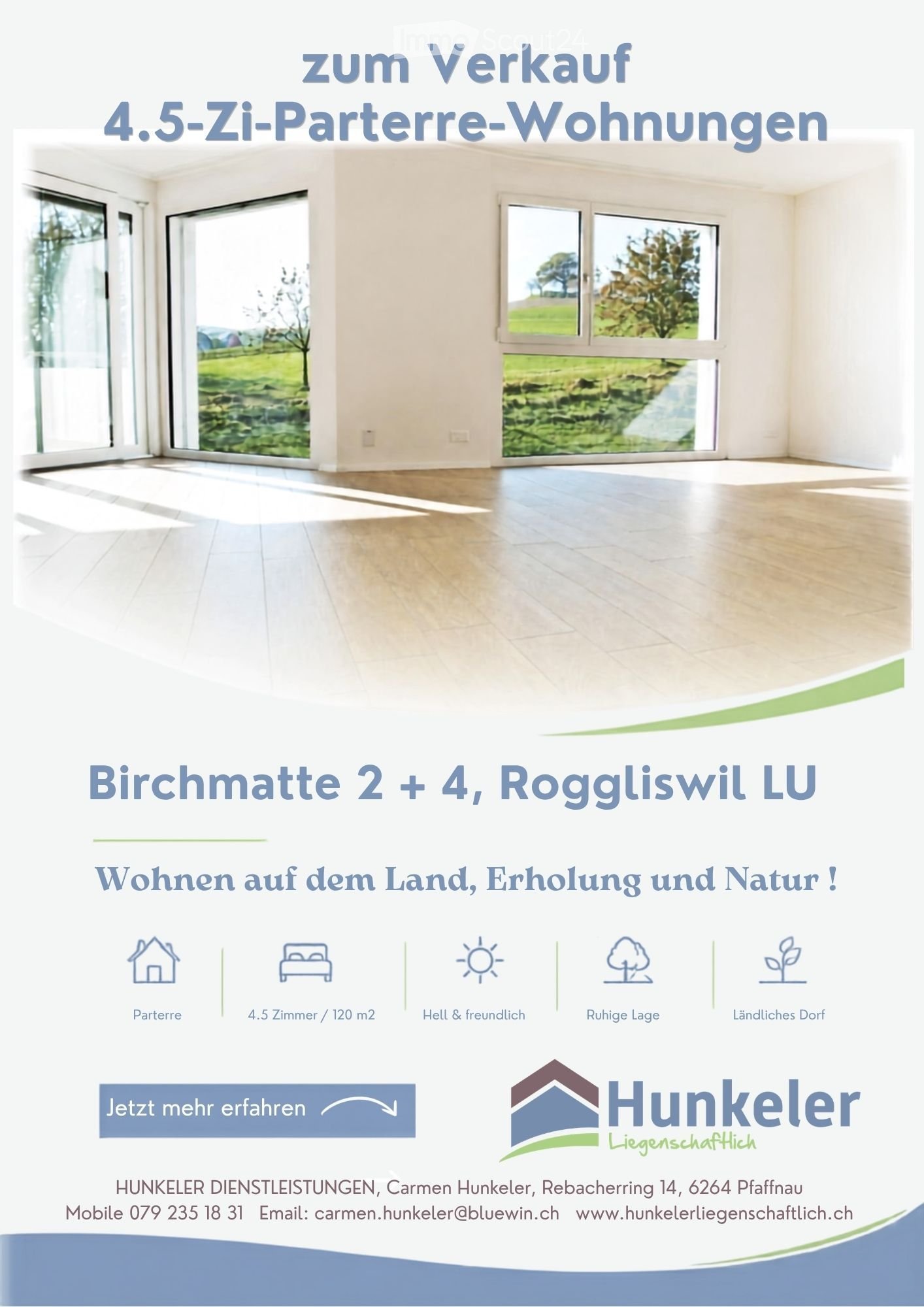 Empty room with large windows and wooden flooring, showing a scenic outdoor view of greenery and a pathway.