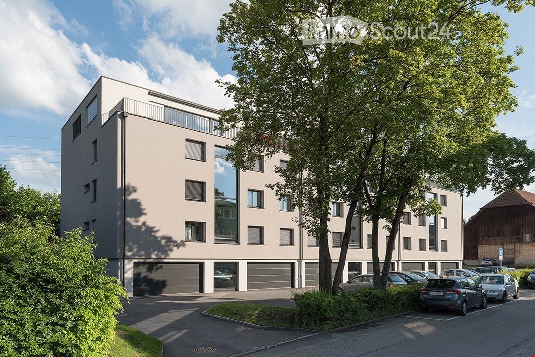 apartment building, beige facade, glass windows, garages