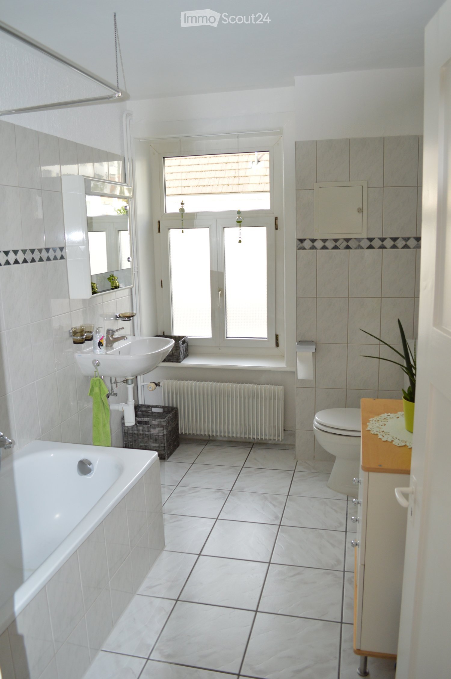 white tiles, bathtub, sink, toilet, radiator, window, plant
