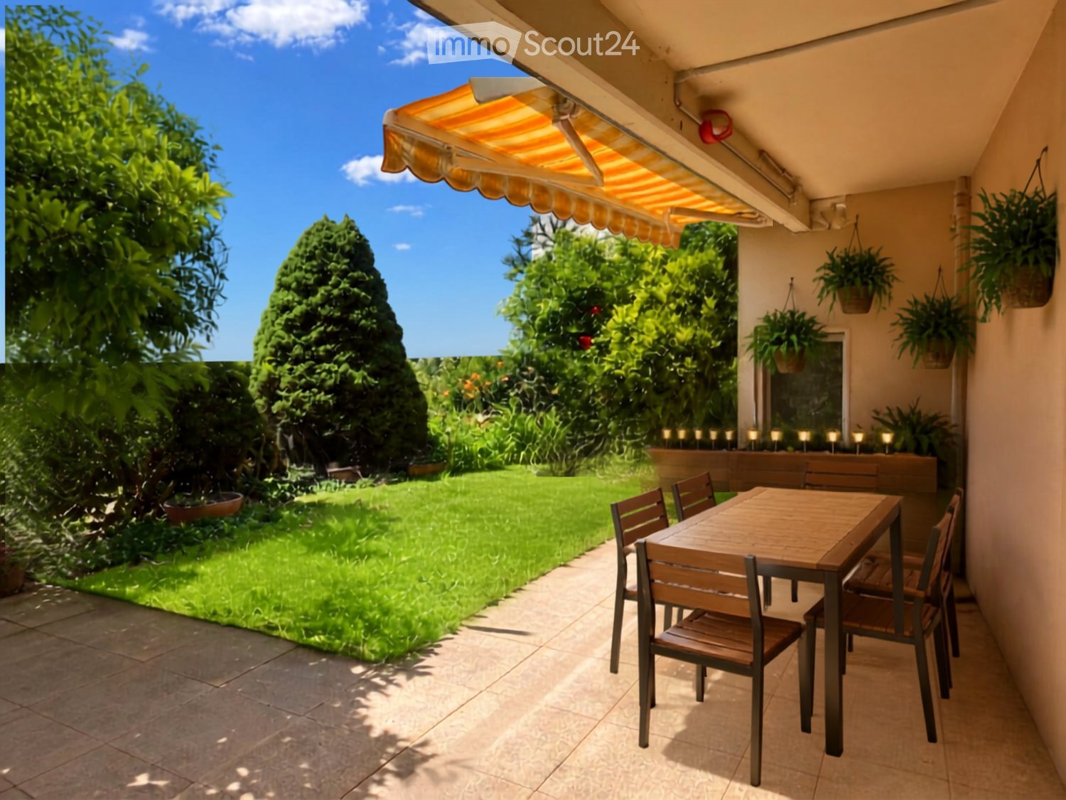 Balcony with a wooden table and chairs, surrounded by greenery and a well-maintained lawn.