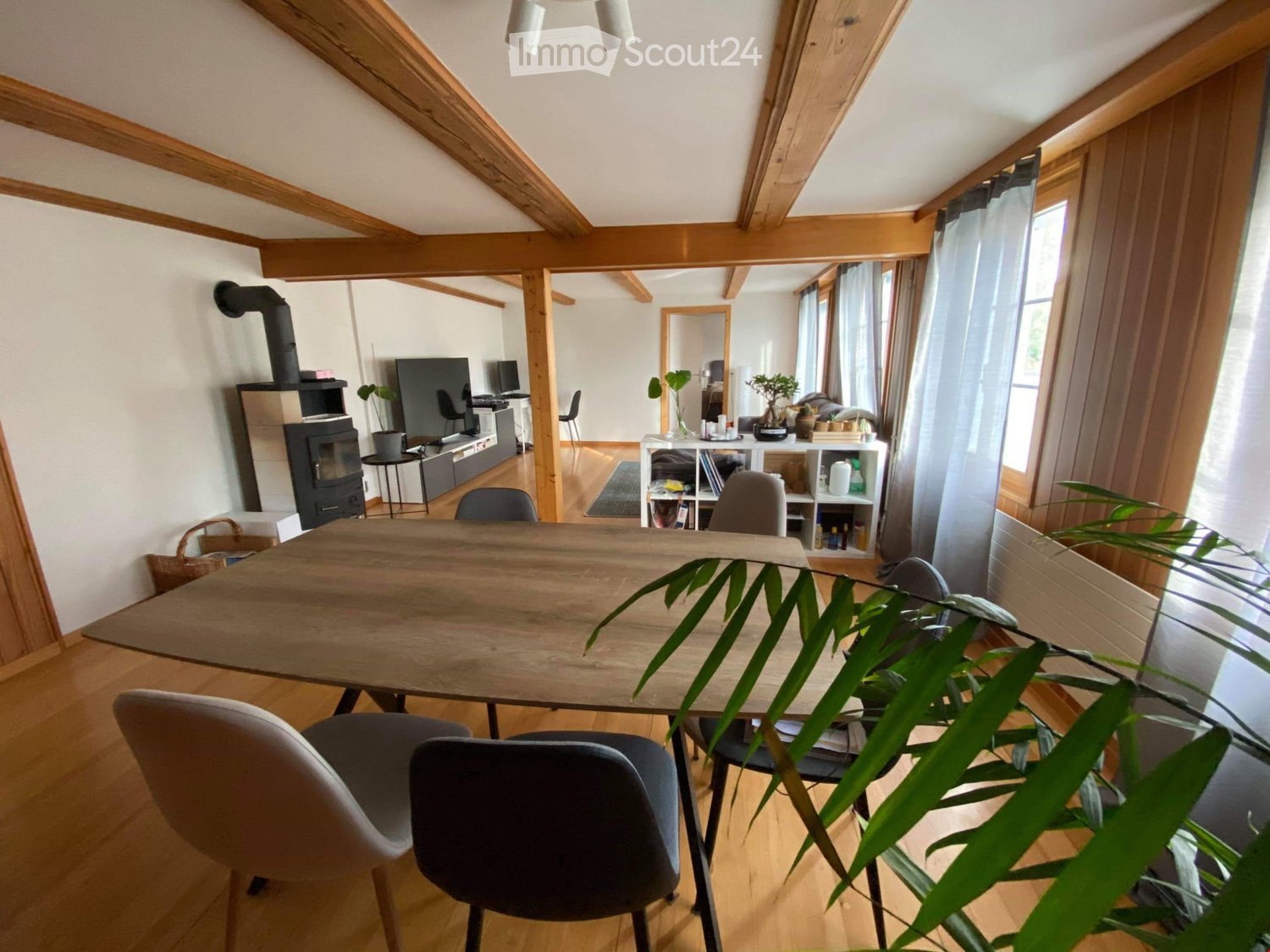 wooden table, white chairs, wooden beams, fireplace