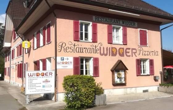 Pink building with white trim, labeled "Restaurant Widder Pizzeria" with multiple windows and shutters.