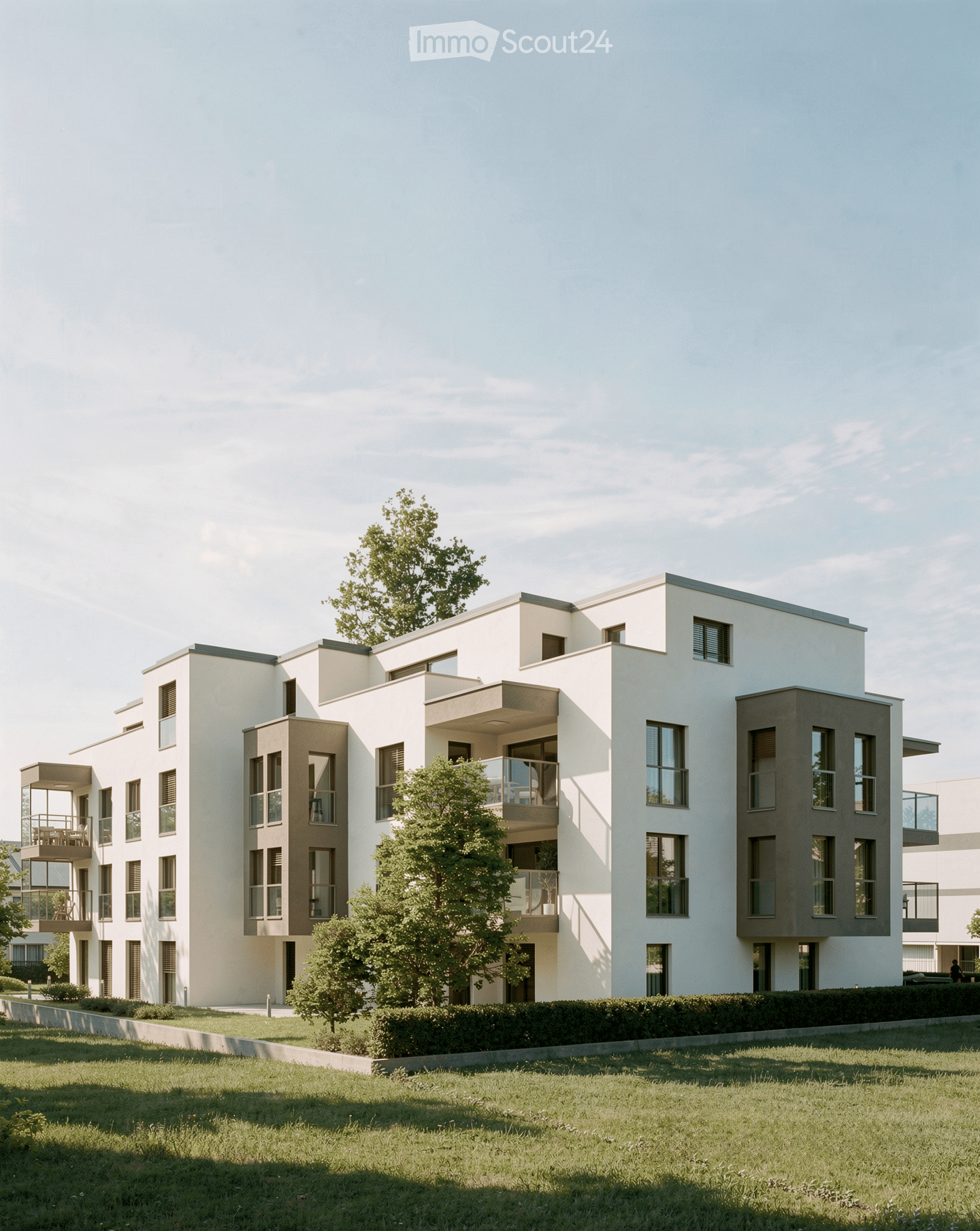 Modern multi-story residential building with white and grey facade, large windows, balconies, and surrounding greenery.