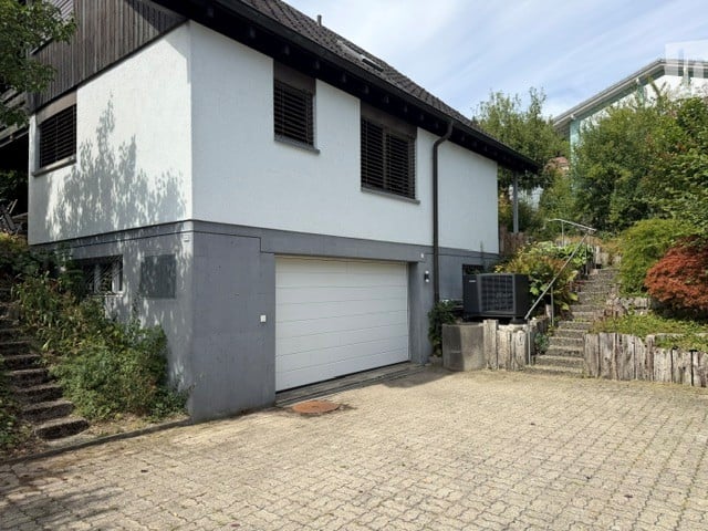 Two-story house with white and grey exterior, garage, and driveway.