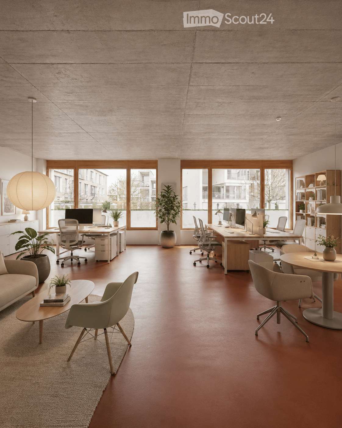 Modern office space with a lounge area and workstations. Features a red floor, large windows, a sofa, coffee table, office desks, chairs, computers, lamps, and plants.