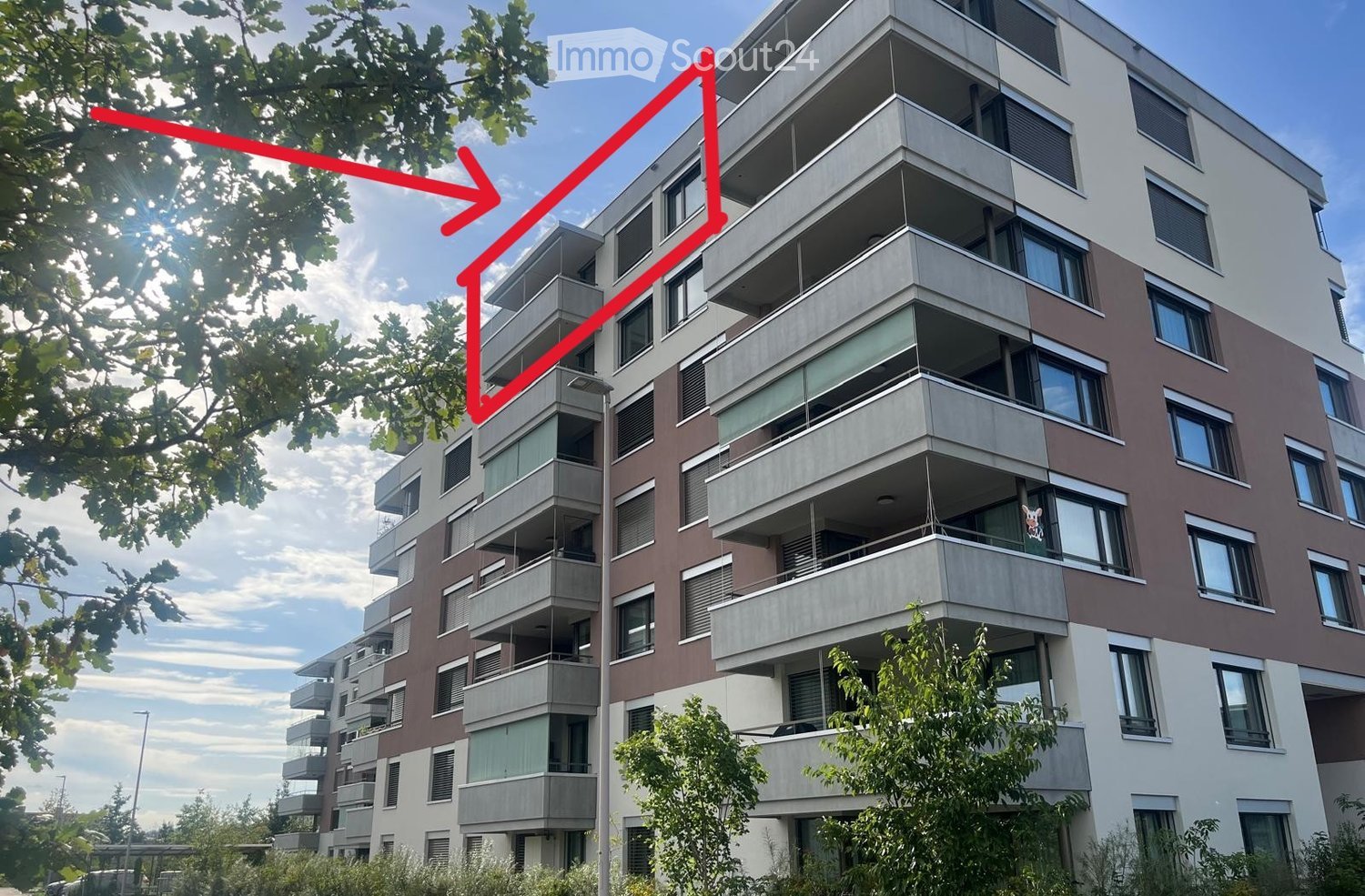 Modern multi-story apartment building with balconies, large windows, and contemporary design.