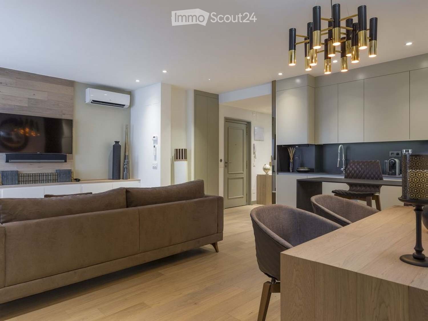 Modern living and dining area with a sofa, dining table, chairs, kitchen area, and decorative items.