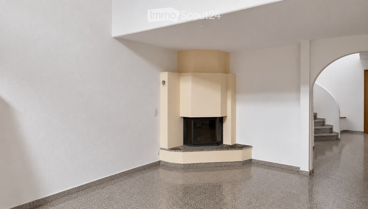 Modern hallway with a built-in fireplace, white walls, and a staircase leading upwards.