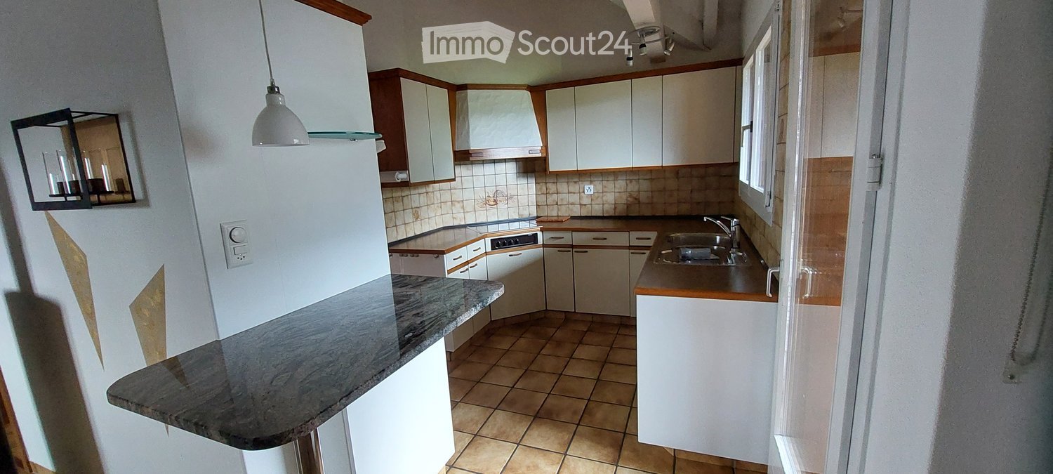 Modern kitchen with white cabinets, granite countertop, stainless steel sink, and built-in appliances.