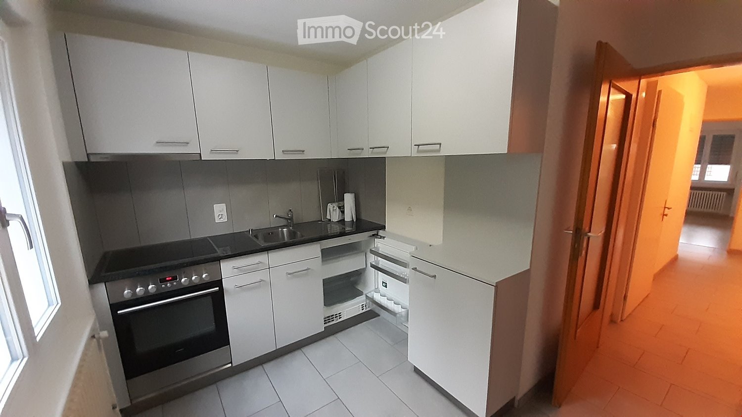 white kitchen, tiled floor, stainless steel oven and sink, white cabinets, dishwasher, washing machine