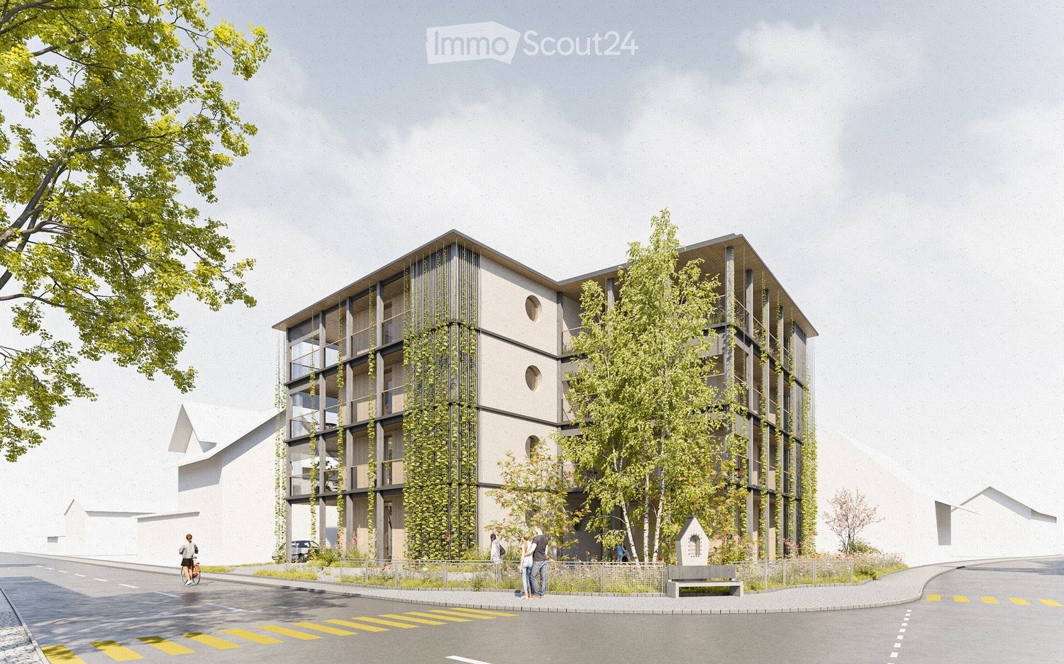 Modern multi-story building with a contemporary design, featuring large windows, balconies, and greenery integrated into the facade. The building is surrounded by trees and a paved area with a bench.