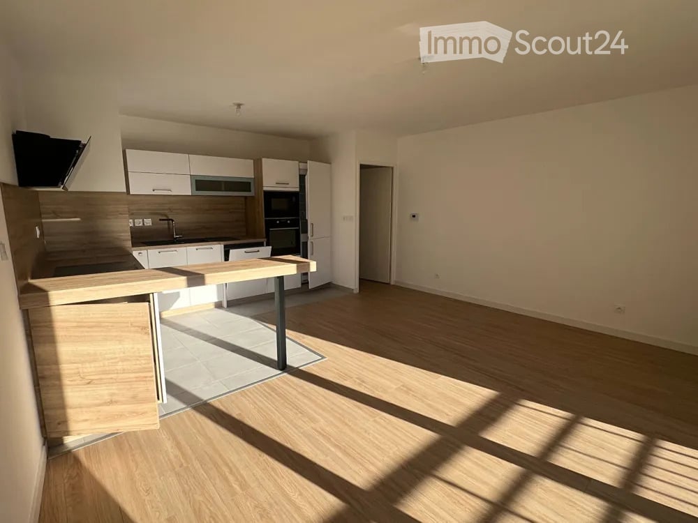 Modern kitchen with white cabinets, stainless steel appliances, and a wooden island. The space is bright with natural light and features a clean, contemporary design.