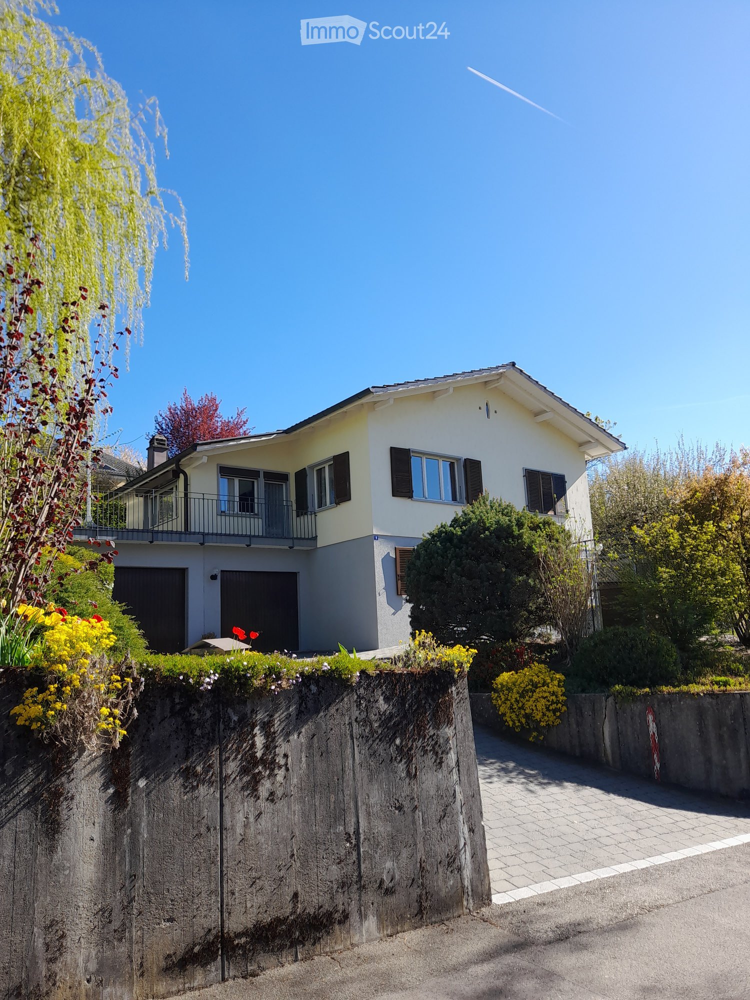 2 story house, white exterior, gray roof, 2 garages, balcony, garden