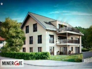Modern two-story house with white facade, multiple balconies, and a well-maintained garden.