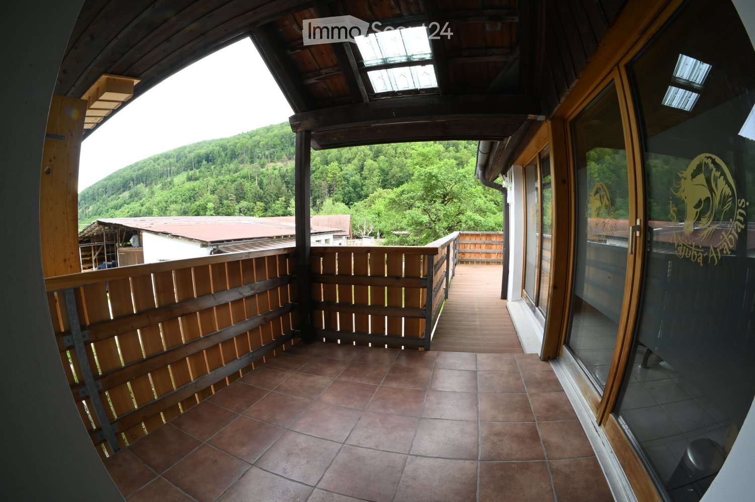 Balcony with wooden railing, tiled floor, and scenic mountain view.