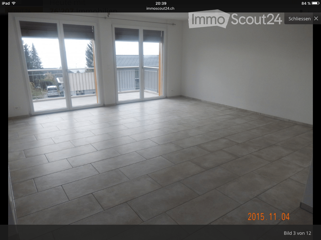 Empty room with tiled floor and large sliding glass doors leading to a balcony area.