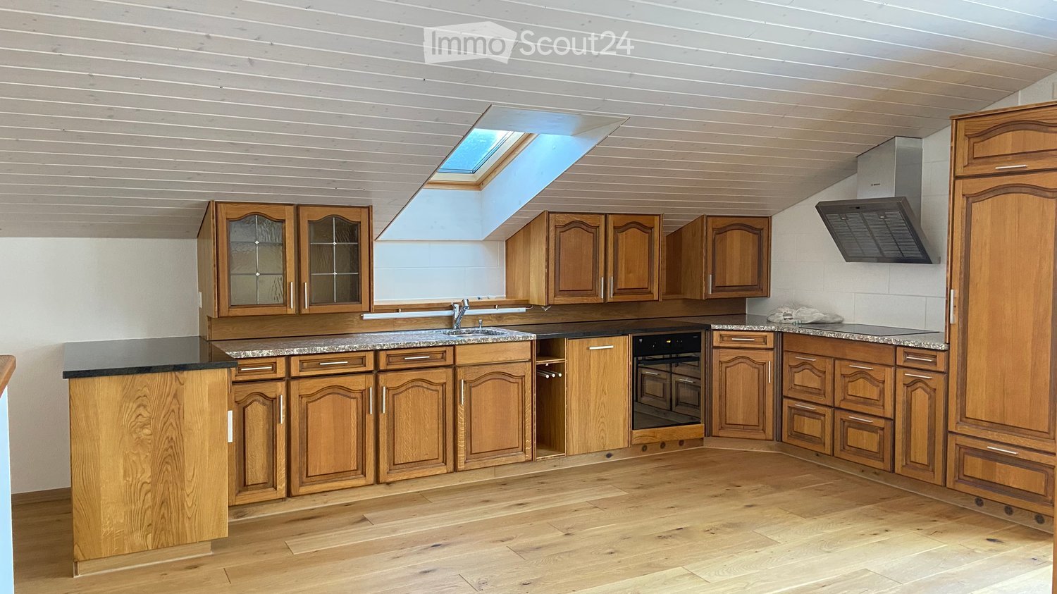 kitchen with wooden cabinets, granite countertops, sink, oven, extractor, skylight