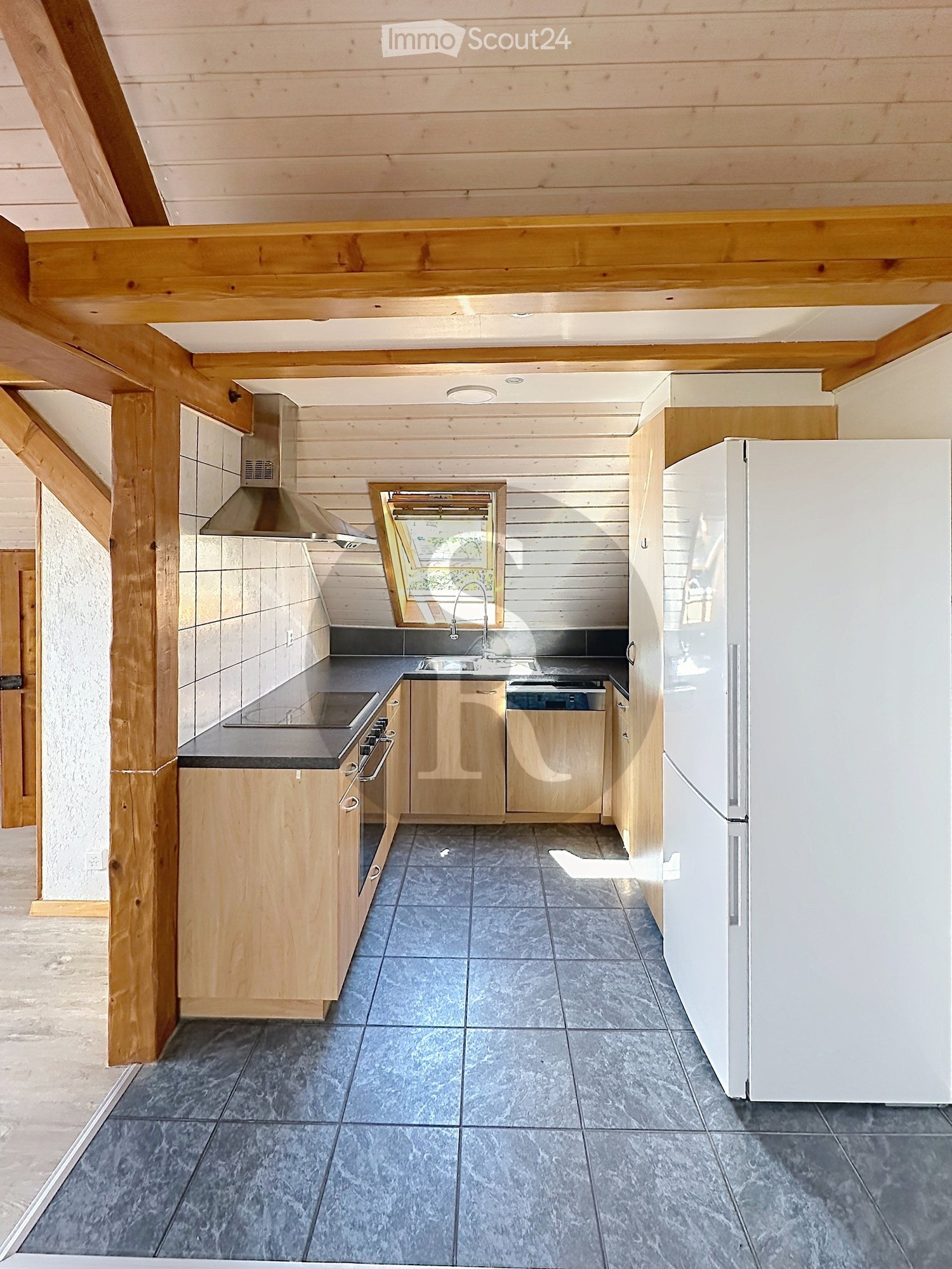 Modern kitchen with wooden cabinets, stainless steel appliances, and a large window above the sink.