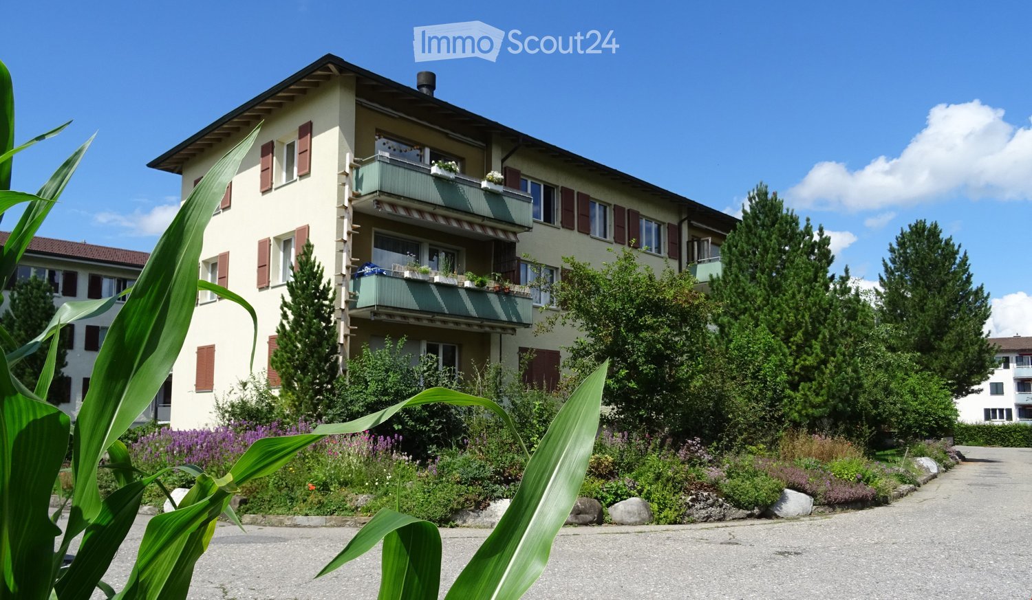 4 story building, balcony, white walls, brown shutters