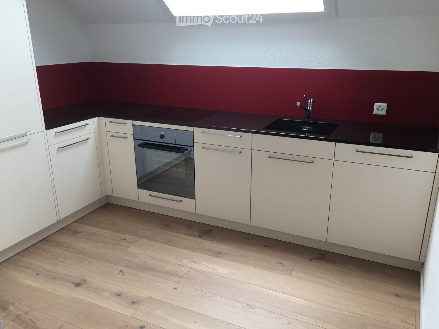 Modern kitchen with white cabinets, dark countertops, and a built-in oven. Features a sink with a modern faucet and a sleek design.