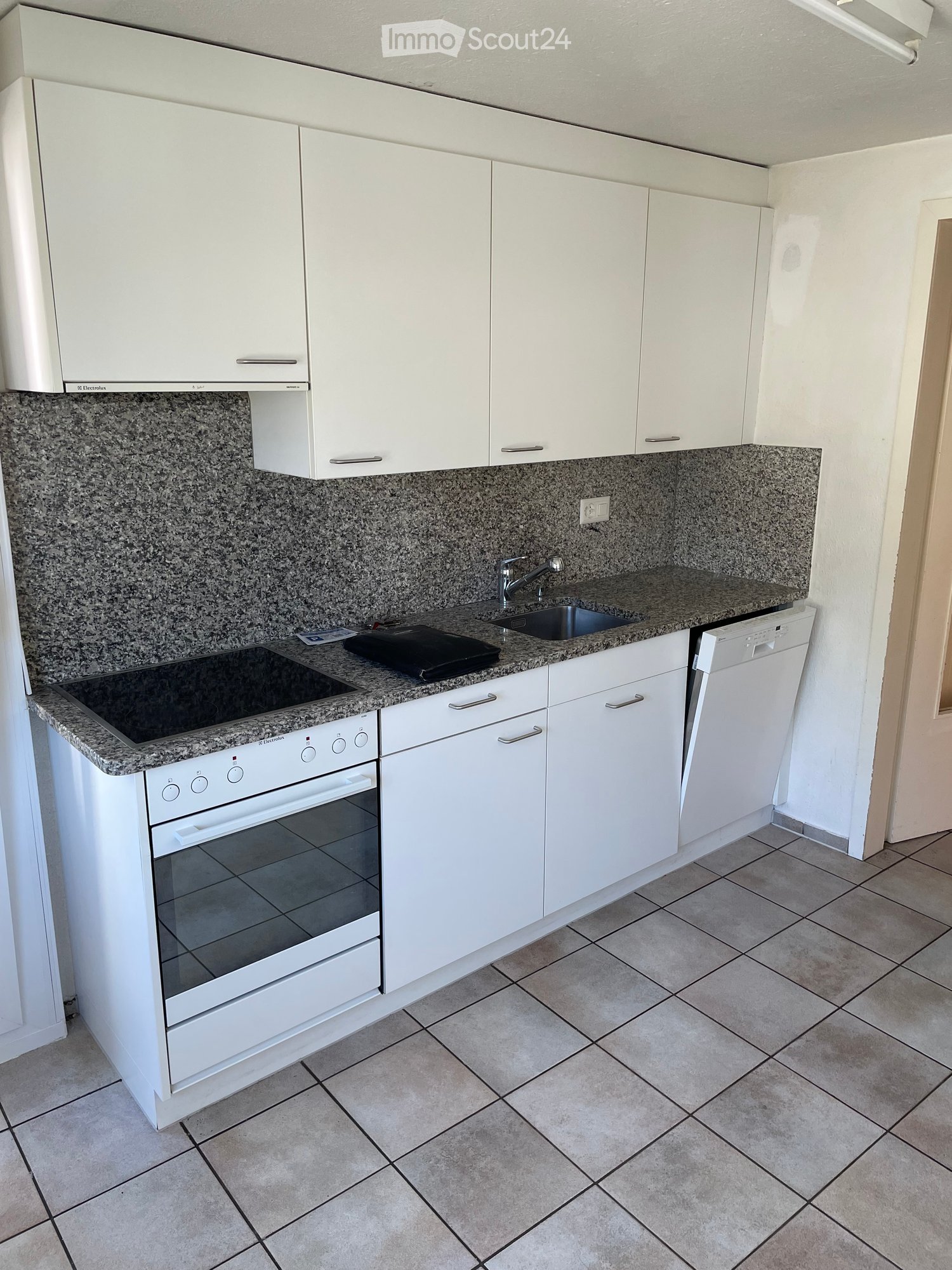 Modern kitchen with white cabinets, granite countertops, electric stove, oven, dishwasher, and sink.