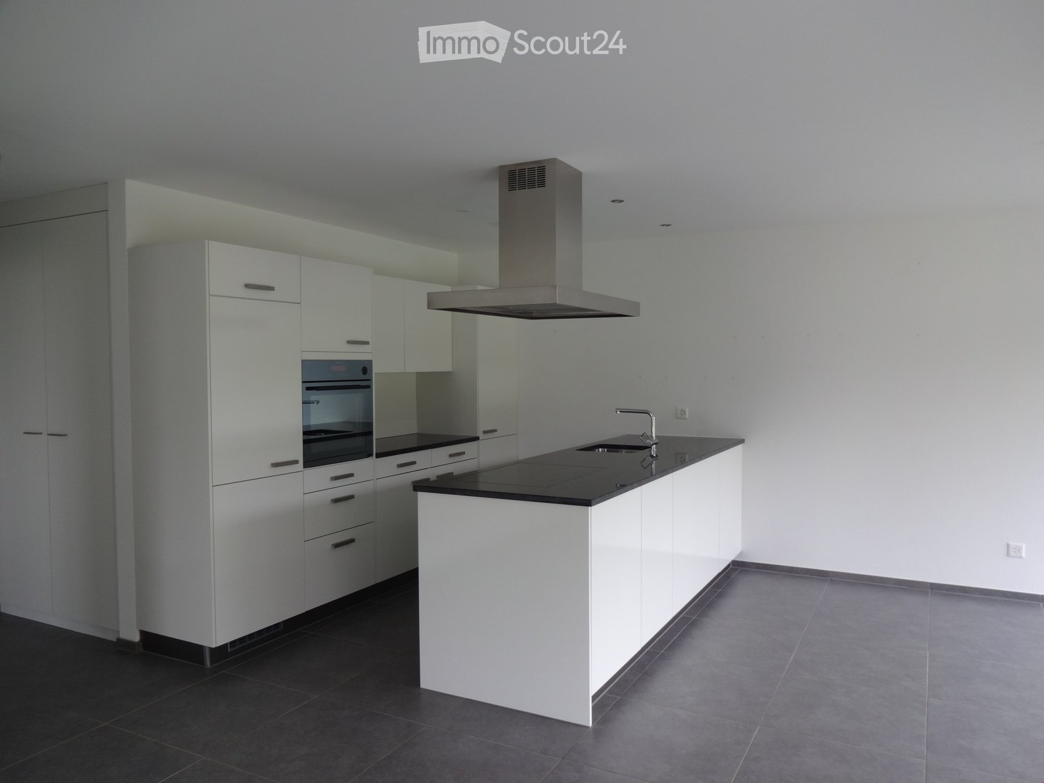 modern kitchen, white cabinets, black countertops, integrated oven and dishwasher, stainless steel extractor hood, white tiled flooring
