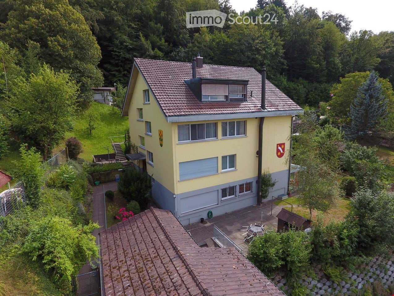 2 story house, yellow exterior, brown roof, two chimneys, attached garage