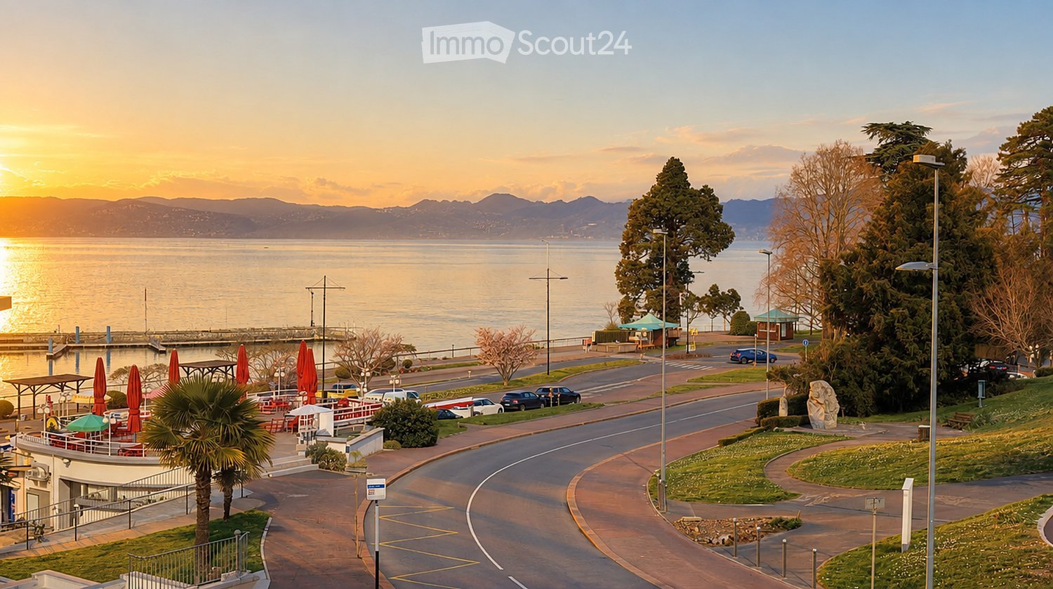Coastal promenade with a view of the ocean at sunset, featuring palm trees, closed umbrellas, parked cars, and a winding road.