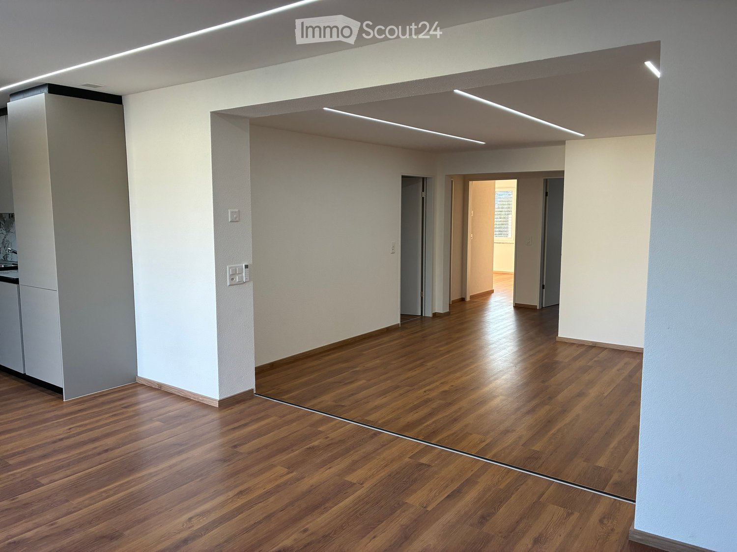 Empty room with wooden flooring, white walls, and recessed lighting. No furniture or equipment present.