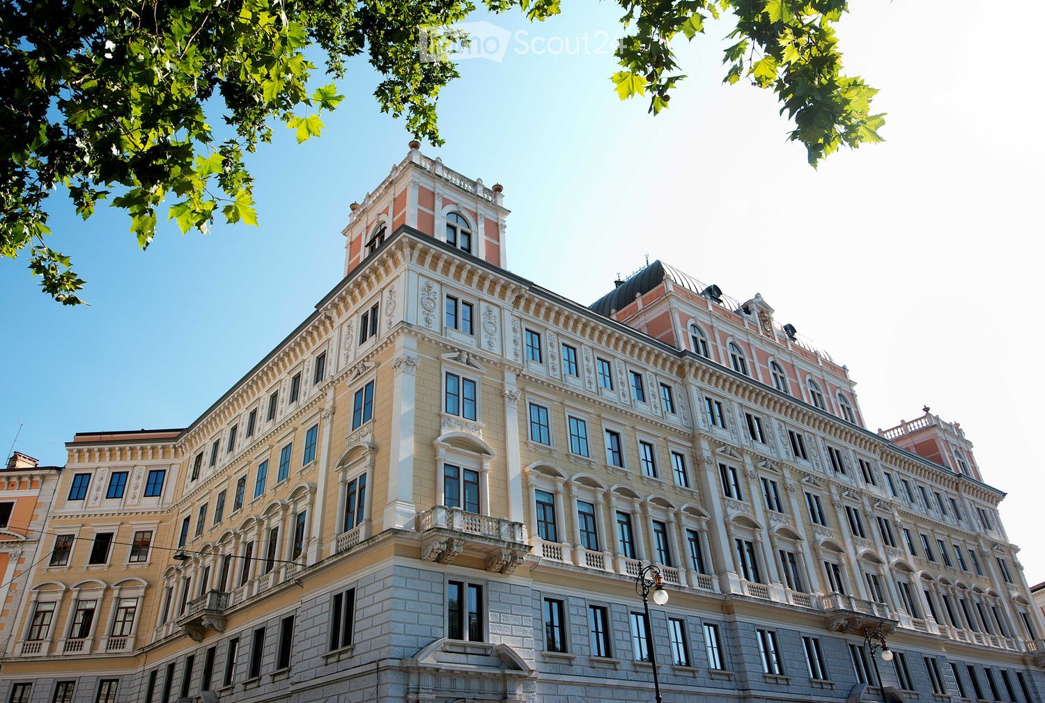 A large, ornate multi-story building with classical architectural details, including arched windows, decorative moldings, and a domed roof section.