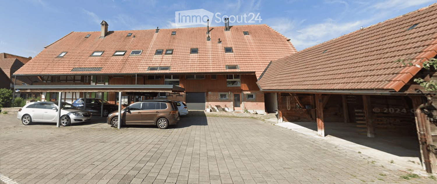 2 story brick house, multiple windows, red roof, cars parked, covered parking, carport