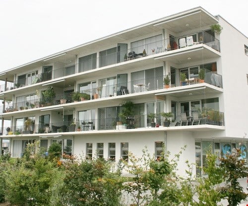 {"visible_features": ["Balcony / Terrace"],"type": "Apartment building","description": "Multi-story apartment building with balconies on each floor, surrounded by greenery and landscaping"}