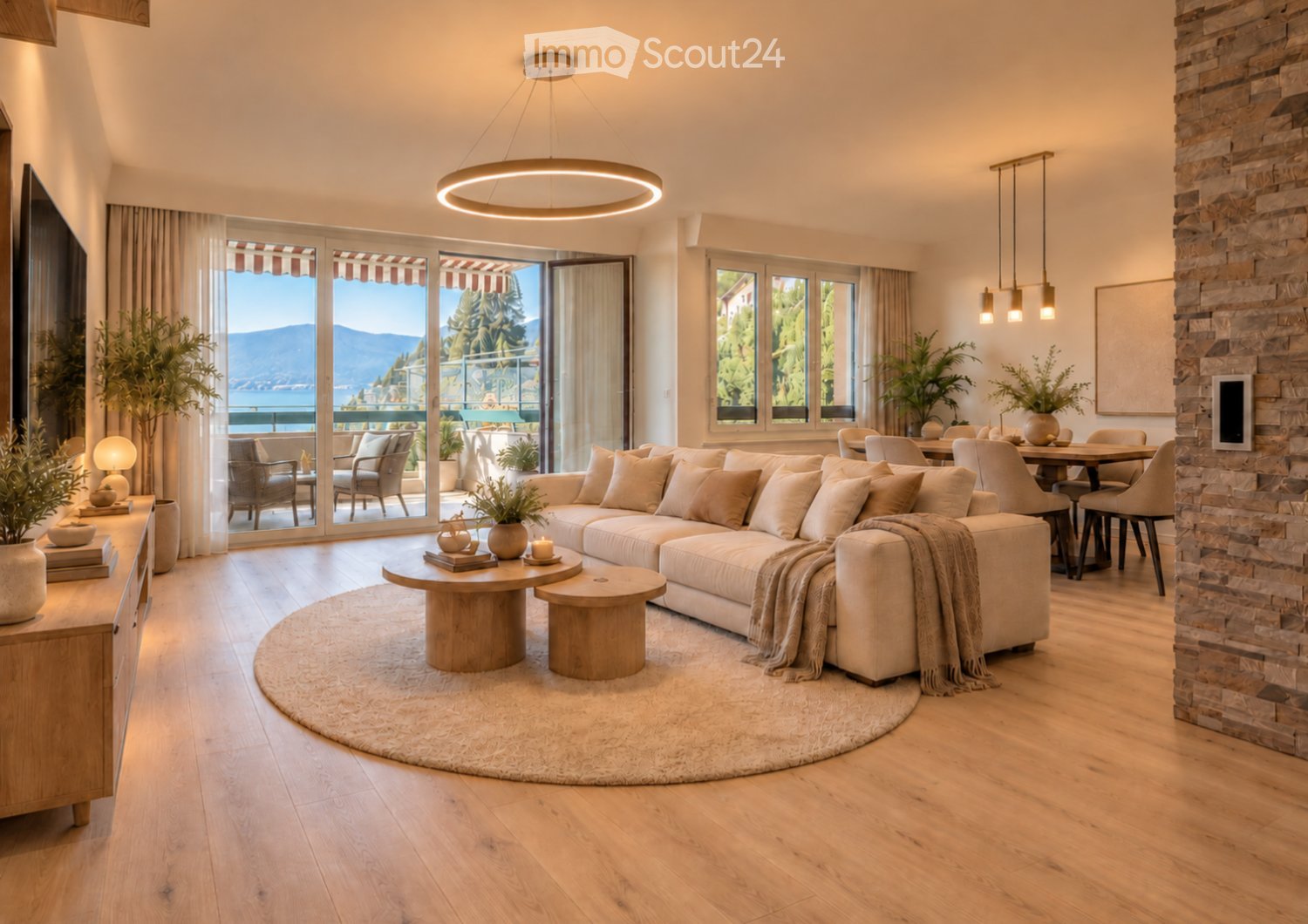 Modern living room with large windows and a view, featuring a sectional sofa, coffee table, dining area, pendant lights, and decorative plants.