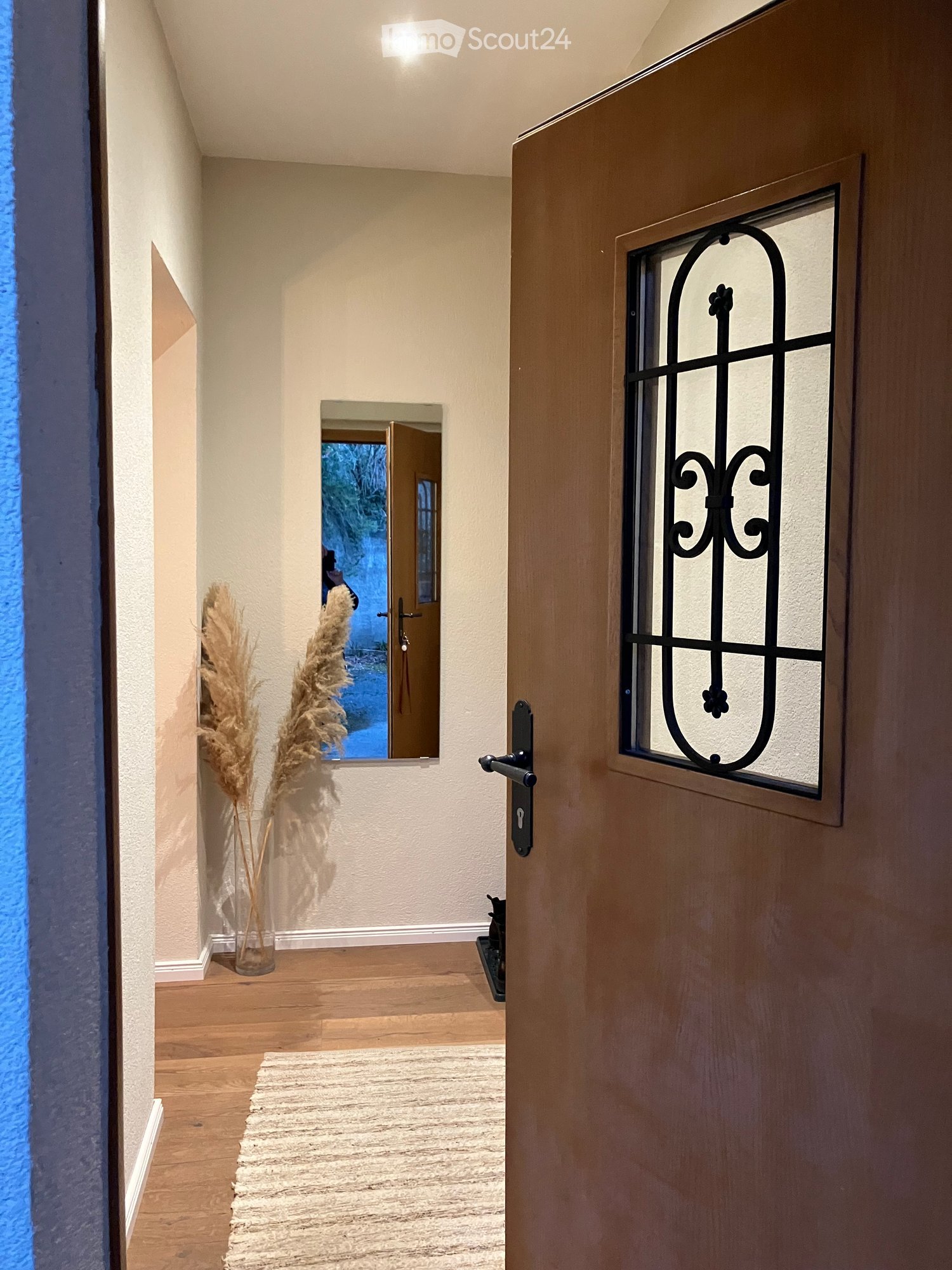 {"visible_features": [],    "type": "Corridor",    "description": "wooden door, glass window with black frame, hallway, floor carpet, potted plant, white wall, room at end of hallway",    "localized_descriptions":        {        "EN": "Wooden door,