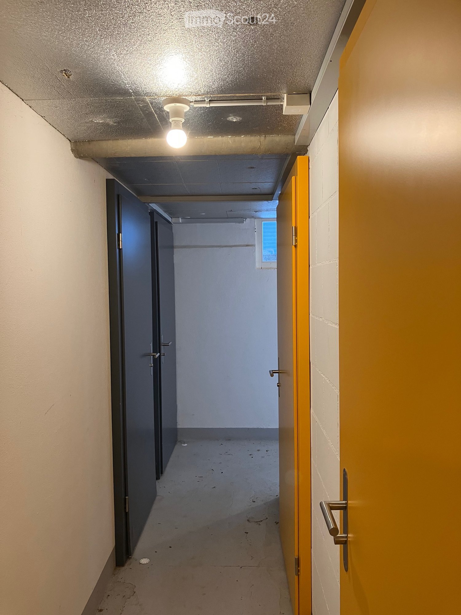 {"visible_features": [], "type": "Corridor", "description": "Long corridor with doors, ceiling light, yellow walls, and an open door on the right"}