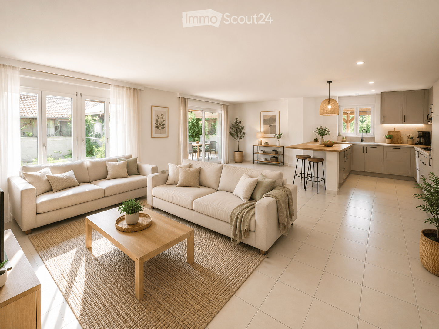 Bright, open-plan living and dining area with a modern kitchen. Features include two large sofas, a wooden coffee table, a kitchen island with bar stools, and large windows with sheer curtains.